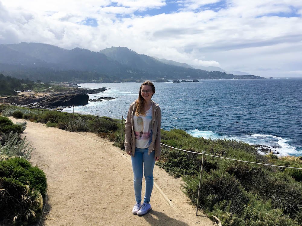 addie standing and smiling on a trail at point lobos state natural reserve