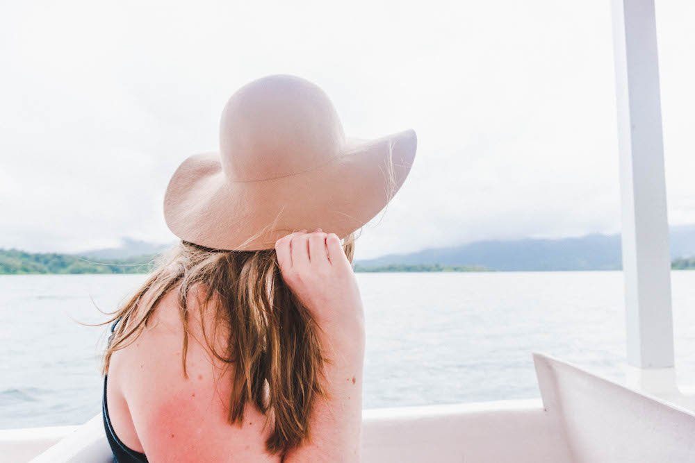 Addie holding onto her hat on the boat from La Fortuna to Monteverde, Costa Rica