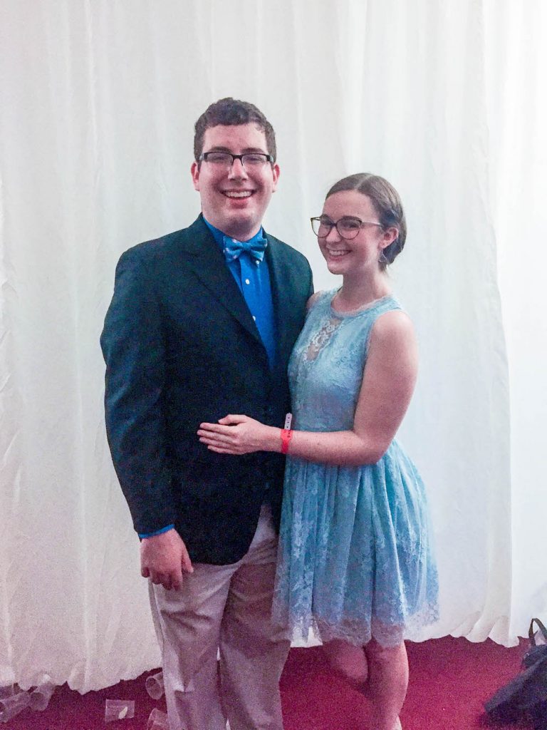 Addie and Daniel in formalwear smiling at the camera