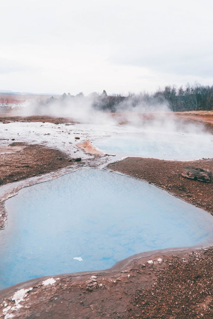 Steam rising from a trio of hot springs at the Geysir Geothermal Area