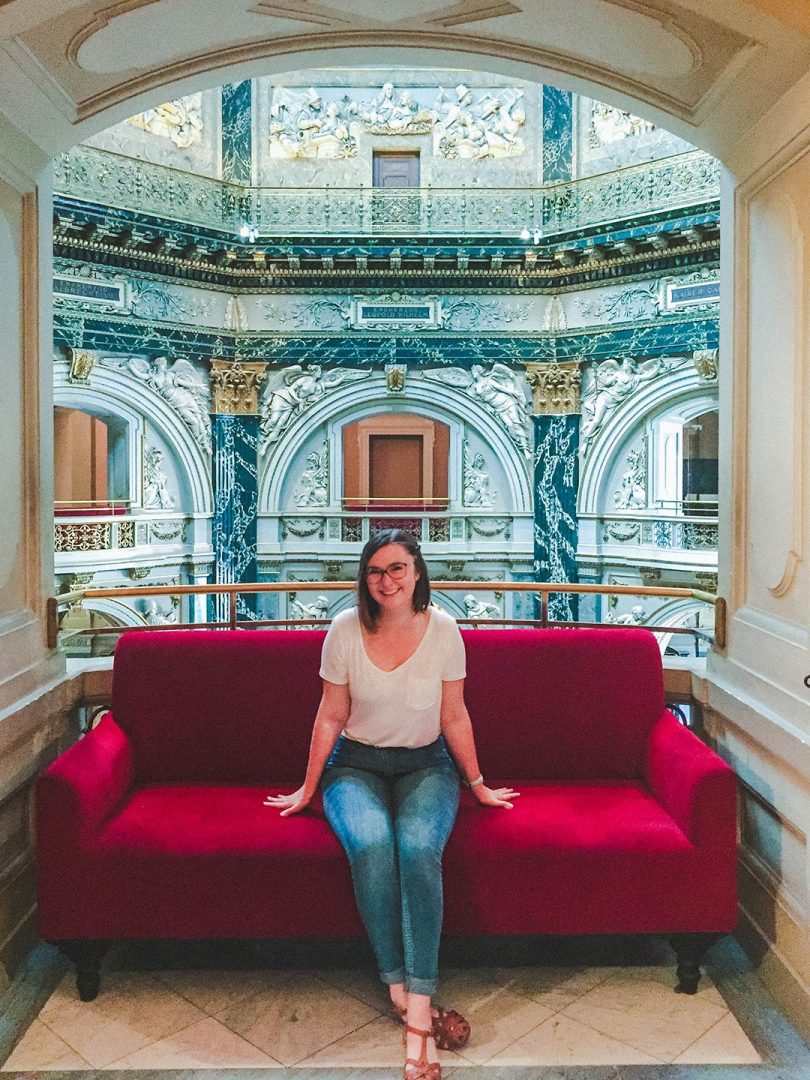 Addie sitting on a red couch in the Art History Museum in Vienna, Austria