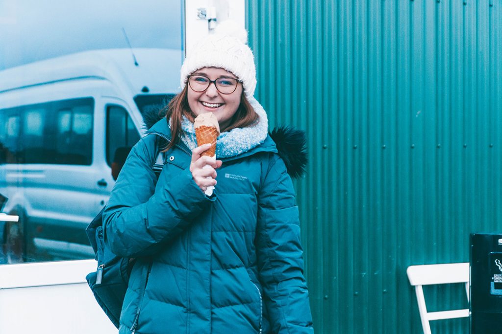 Addie smiling and holding her salted caramel ice cream
