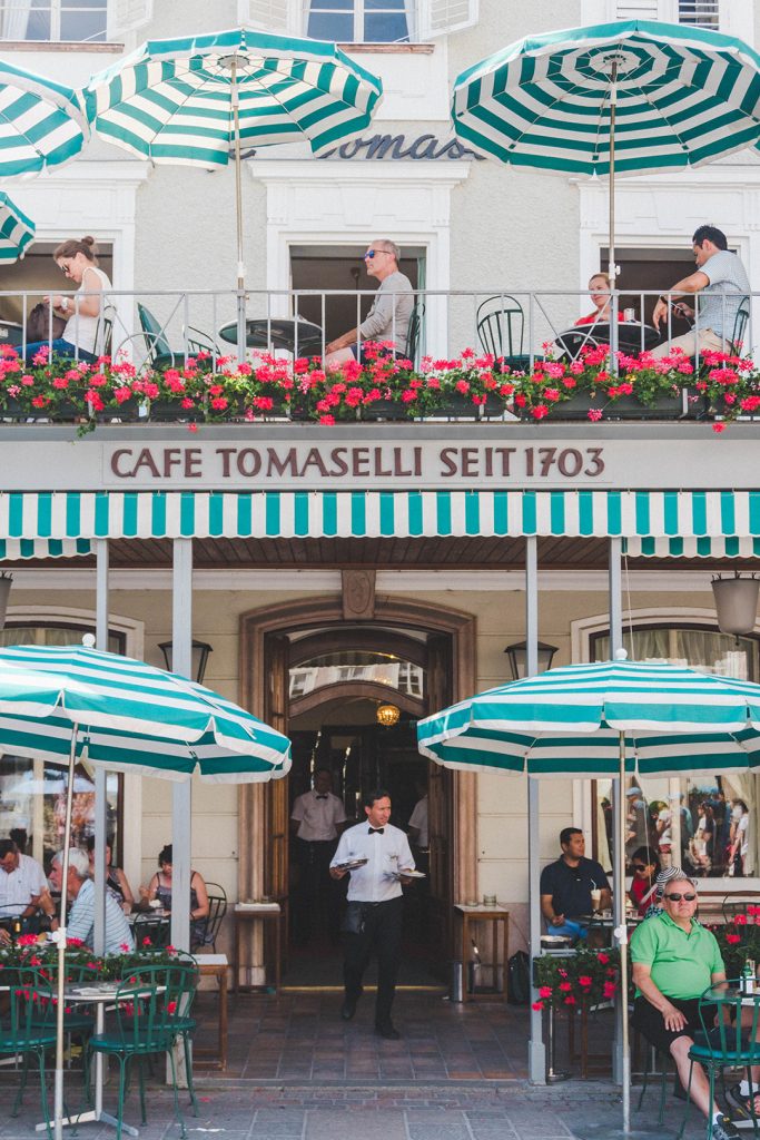 The outside of Cafe Tomaselli in Salzburg, Austria, with adorable green and white striped umbrellas shading outdoor tables