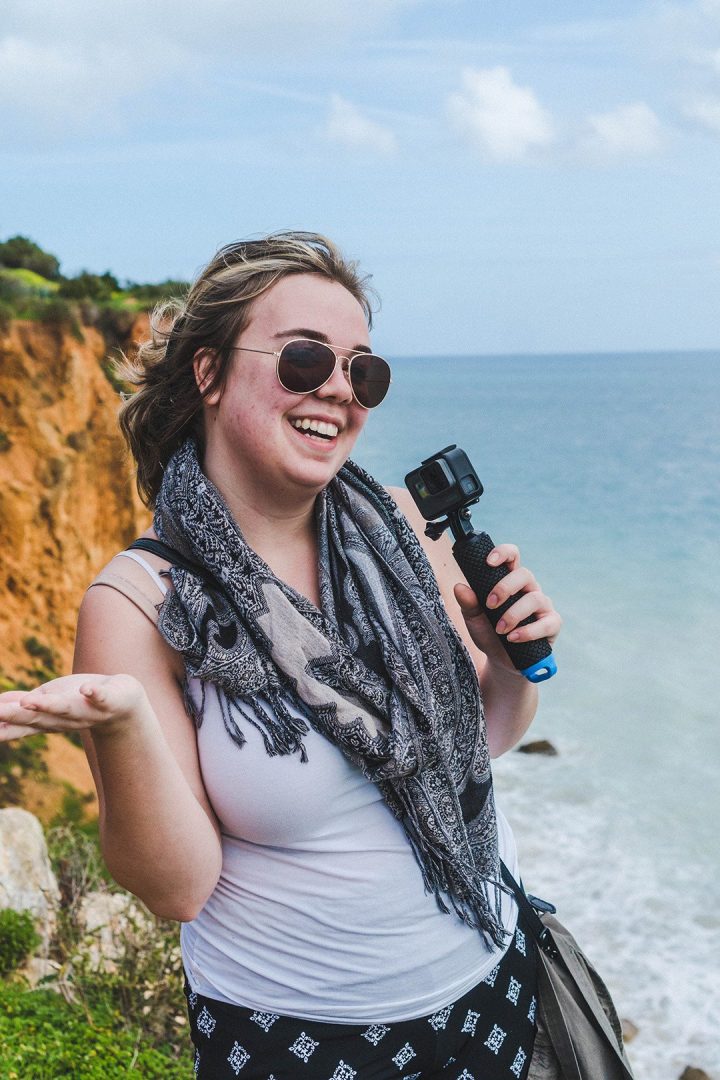 Madison smiling with a Go Pro on our Lagos Cliff Walk