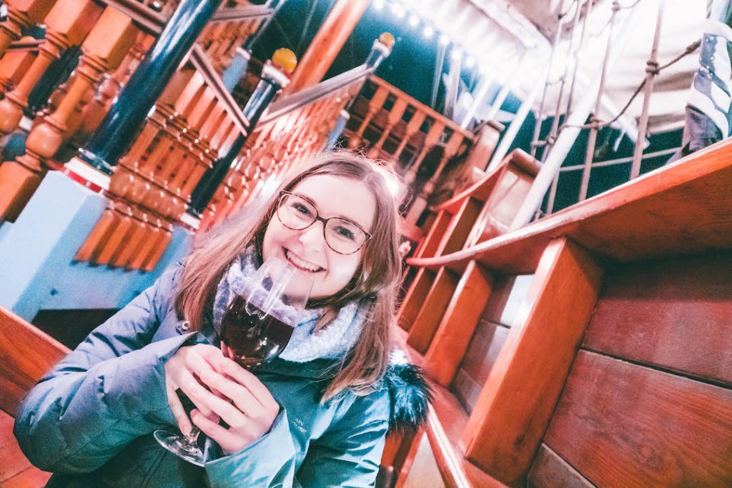 Addie smiling with a full glass of gløgg at the Tivoli Gardens Copenhagen Christmas Market