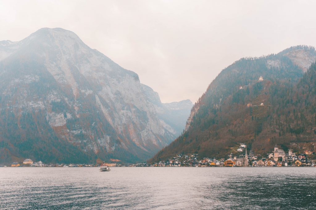 Hallstatt from the other side of the lake: a small expanse of buildings with huge mountains towering behind them.