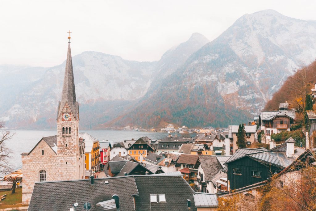 The church and houses of Hallstatt from above in front of a mountain backdrop