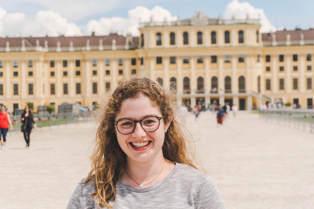 Angela smiling in front of Schonbrunn Palace in Vienna, Austria during her study abroad semester