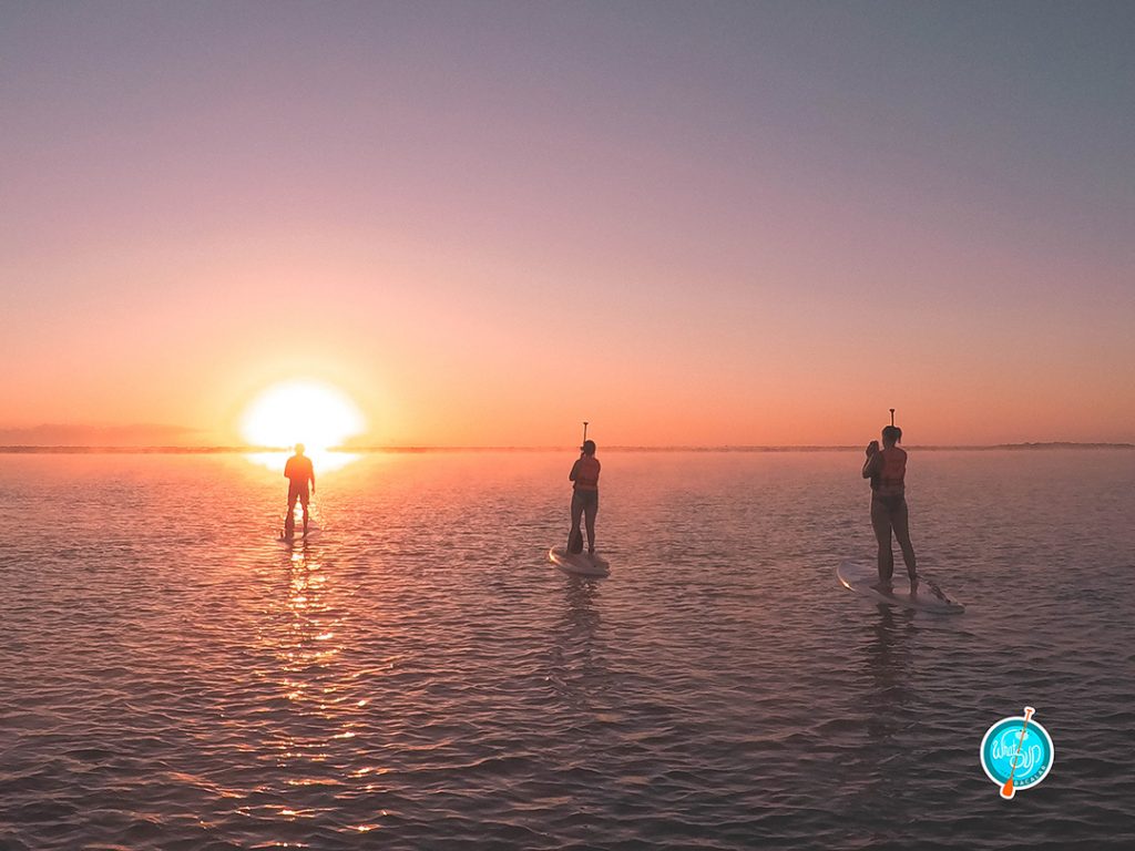 a sunrise SUP tour of the lagoon in bacalar mexico - making friends is one of the best reasons to travel solo