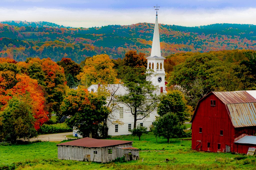 A white church amongst fall color trees in Vermont