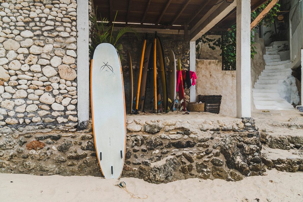 A surfboard leaned against a wall at a bali surf camp