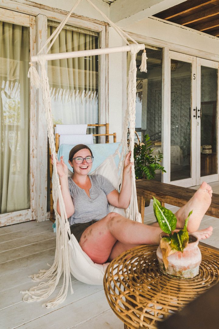 Addie smiling on a hanging chair on the terrace
