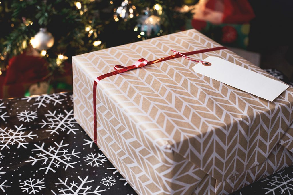 A gift box with fair isle print under a christmas tree - travel gifts for her