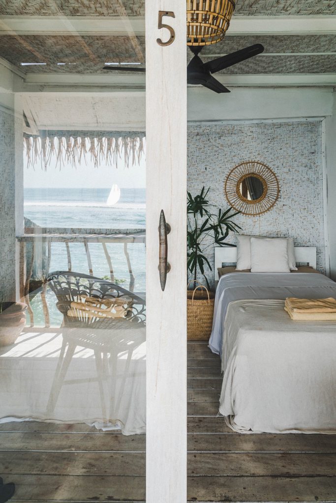 sliding glass door opening up to a bedroom at this bali surf camp