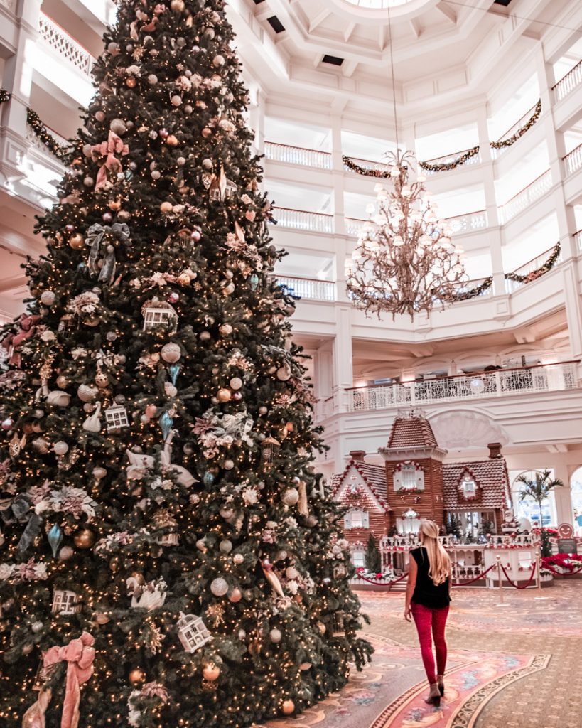 a woman standing looking up at a giant christmas tree in the lobby of a hotel in Orlando, Florida