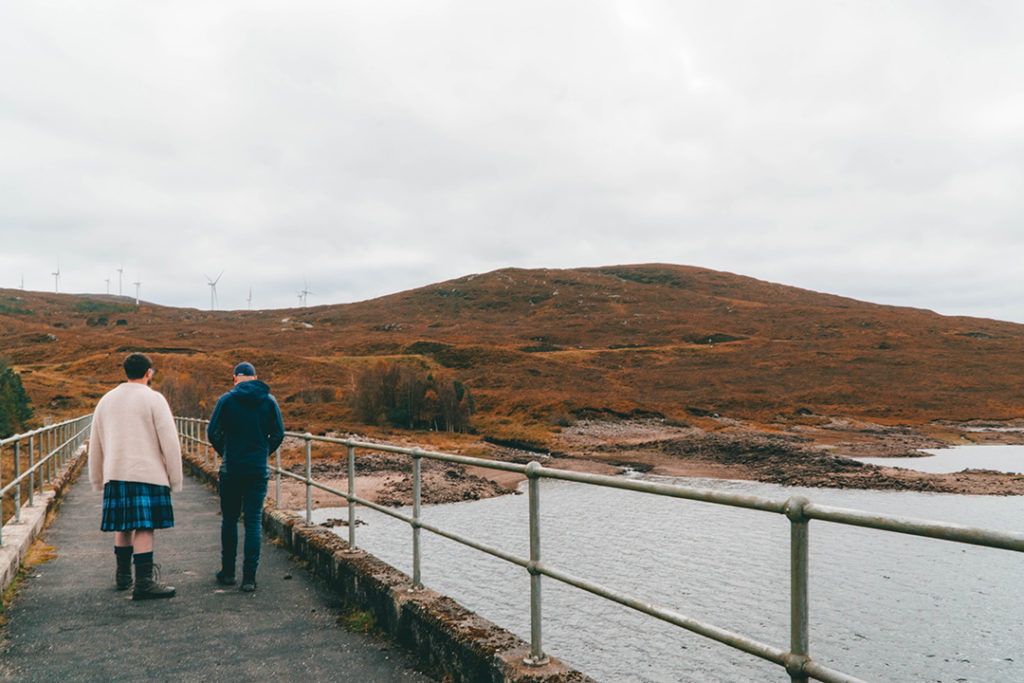 2 men walking over a dam