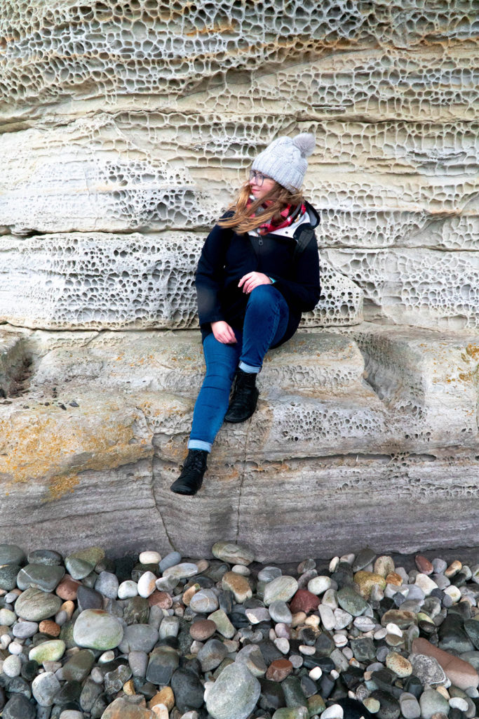 addie sitting on a cliff at elgol