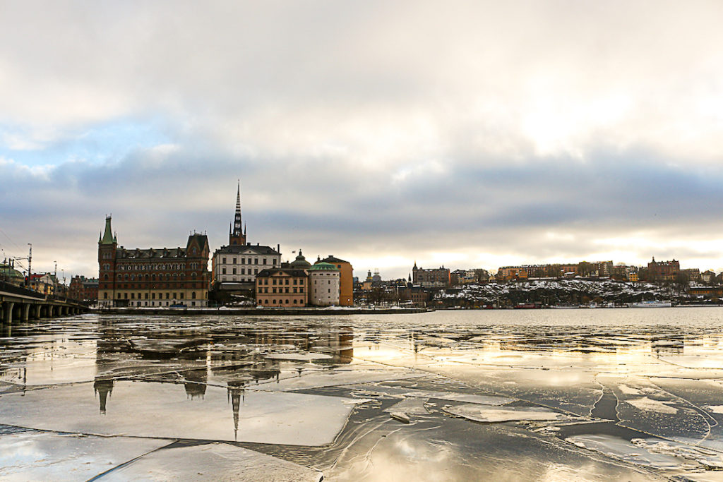 ice on a lake with buildings in the background in Stockholm, Sweden