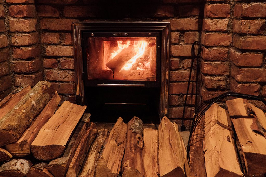 a small fireplace with a bunch of wood stacked up in front of it