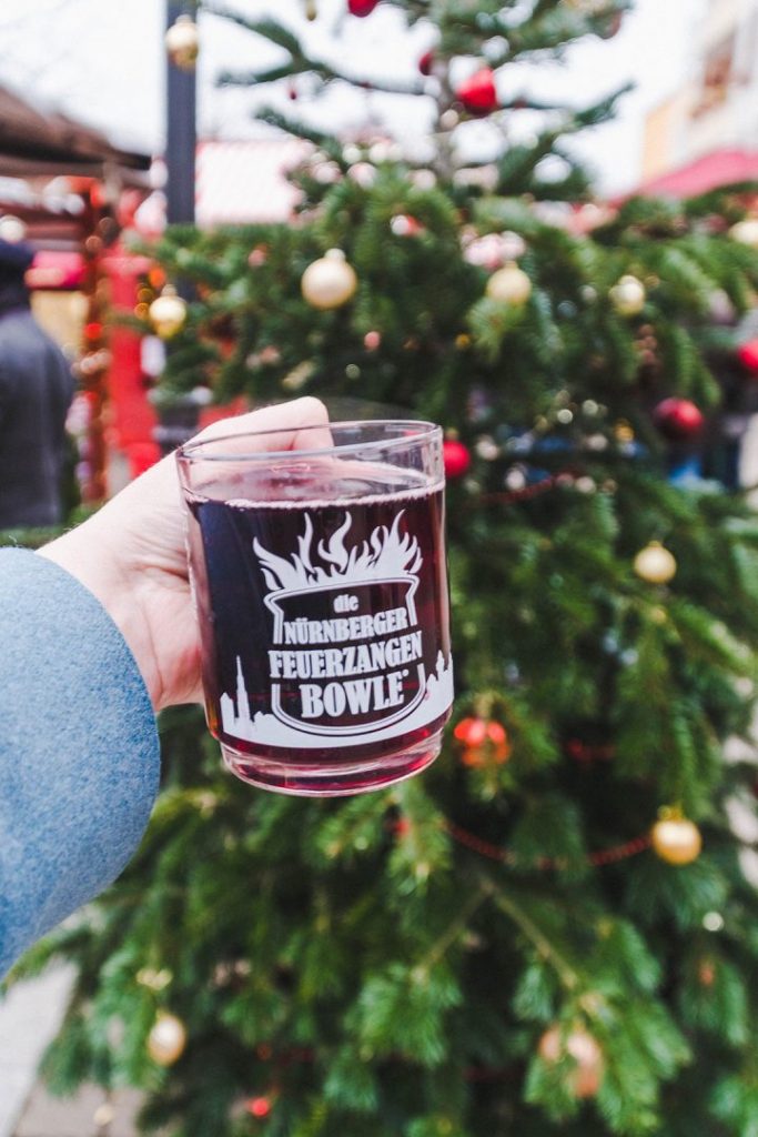 A hand holding up a mug of feuerzangenbowle