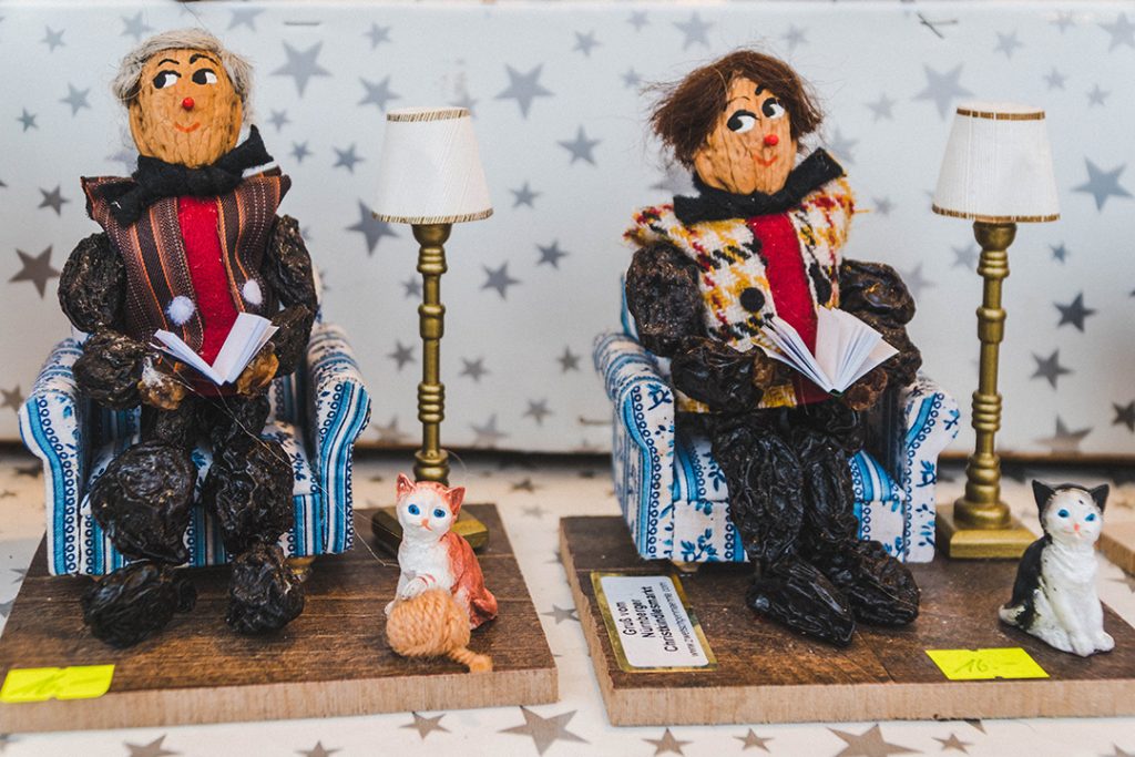 two zwetschkemanne (prune men) sitting in chairs and reading books