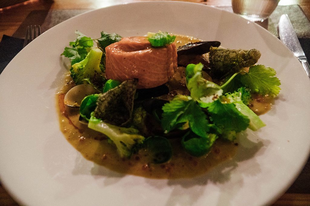 salmon on top of a bed of vegetables