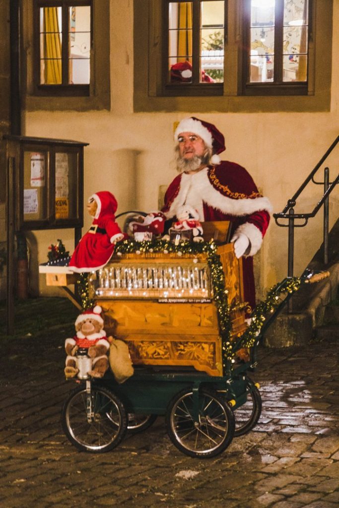 A man dressed as Santa Claus at a rolling machine which plays music