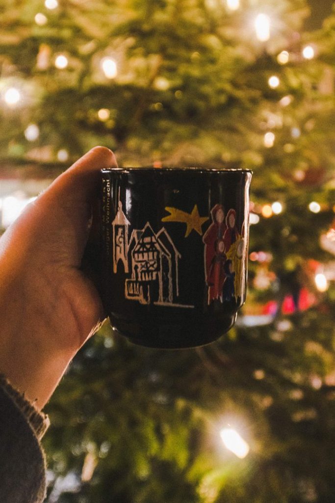 a hand holding up a gluhwein mug at the rothenburg ob der tauber christmas market