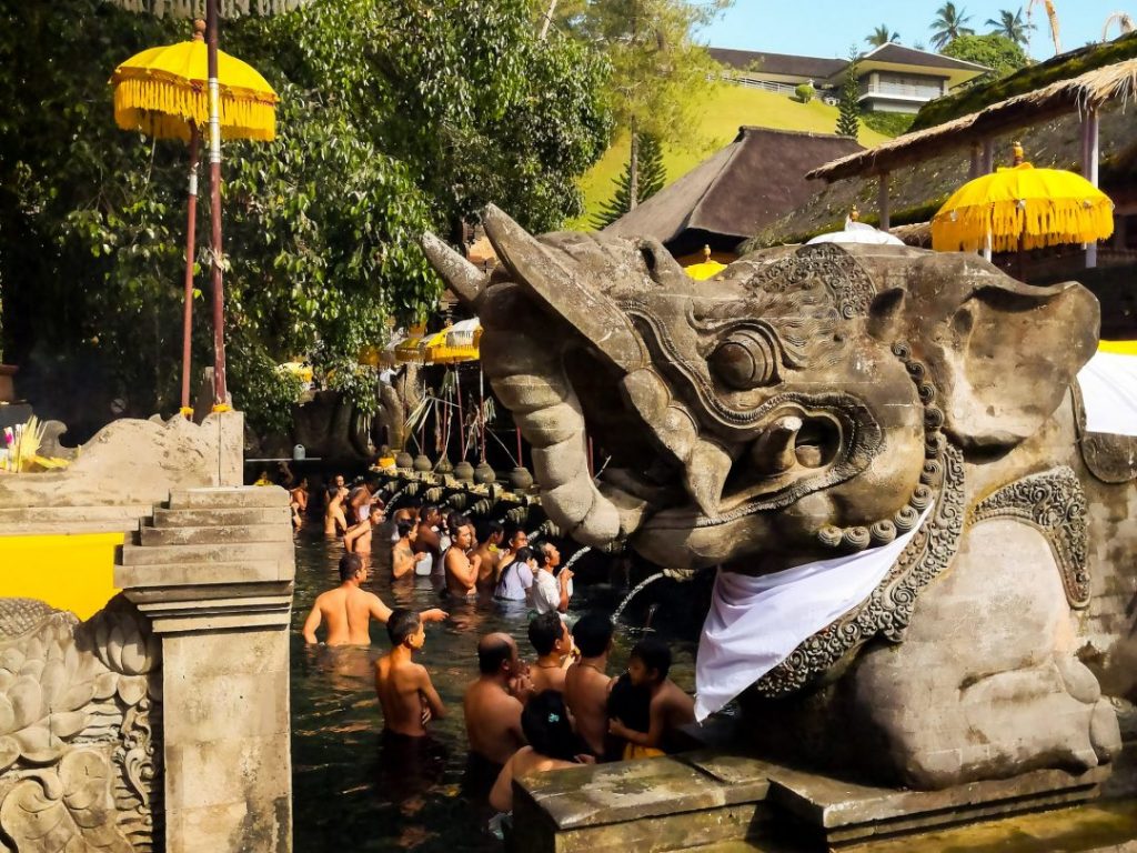 people bathe in the fountains at Titra Empul temple in Bali
