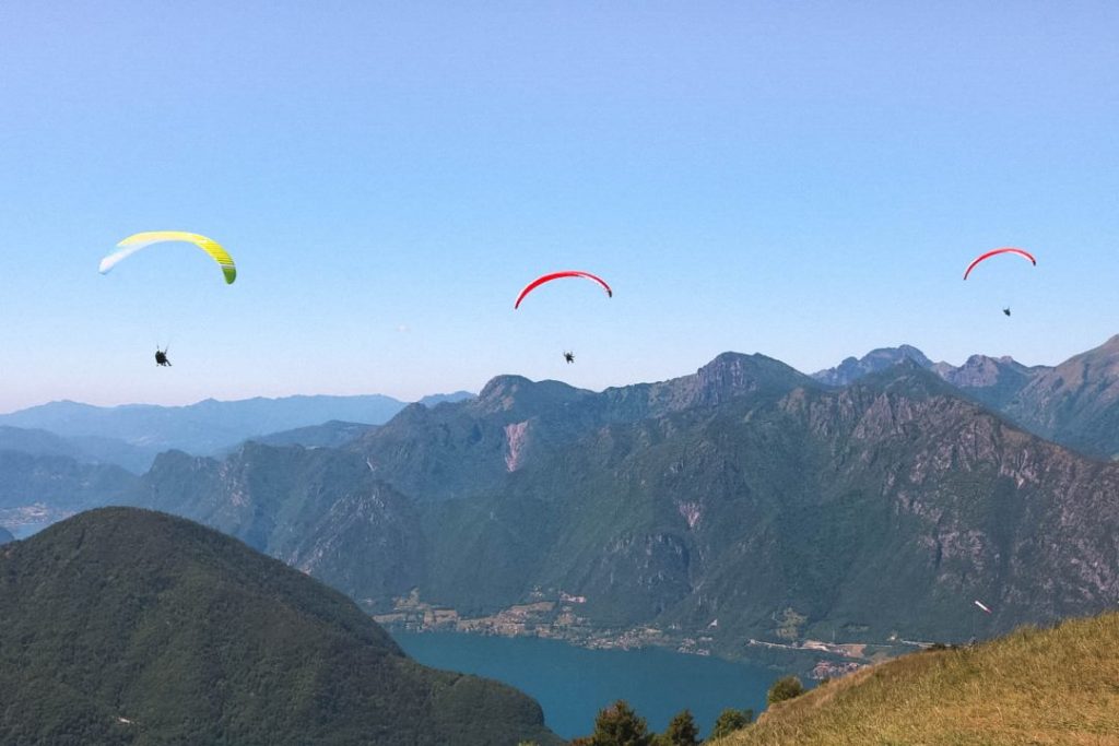 3 Paragliders in the air above Lake Idro in Valle del Chiese, Trentino, Italy