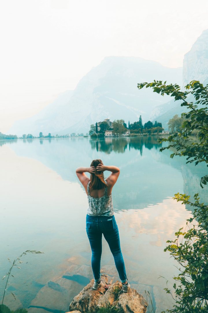 addie standing by a lake looking out at a castle in italy