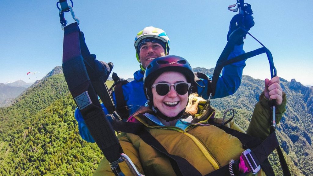 Addie and her paragliding pilot taking a selfie in the air