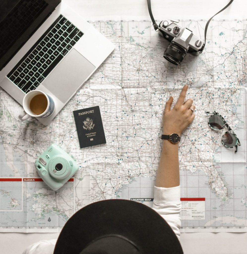 a girl pointing at a map with a camera on top of it