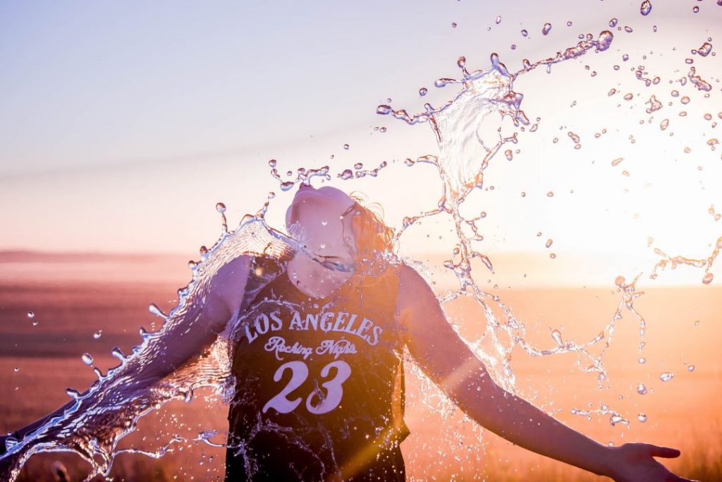 backlit girl splashing water