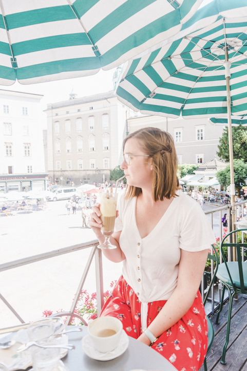 and over exposed picture of addie sipping an eiscafe on a cafe terrace