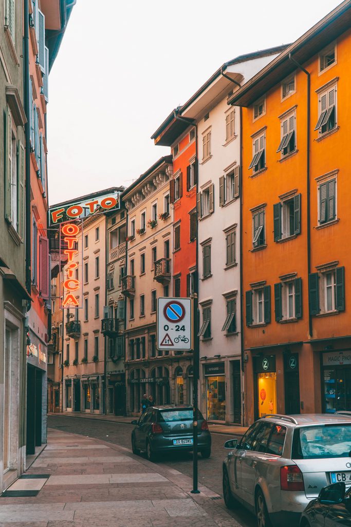 a quaint street of tall, narrow, colorful buildings in trento