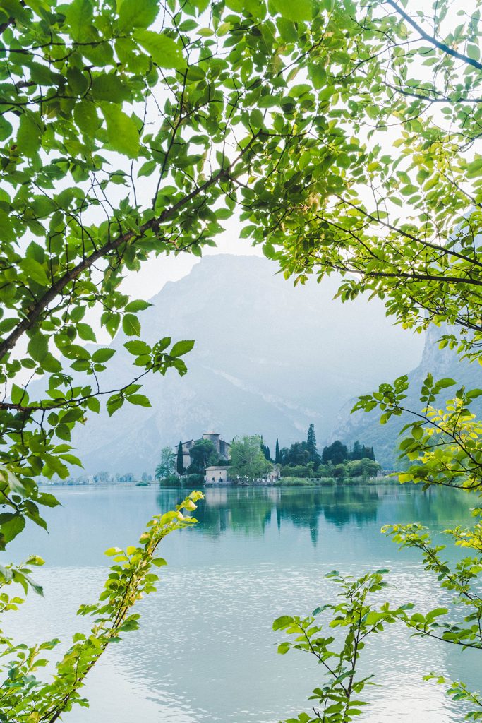 Toblino castle through trees - one of many photos that will inspire you to visit trentino