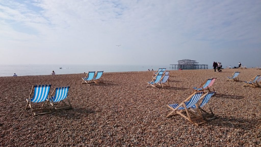blue and white striped chairs on the pebbly brighton beach