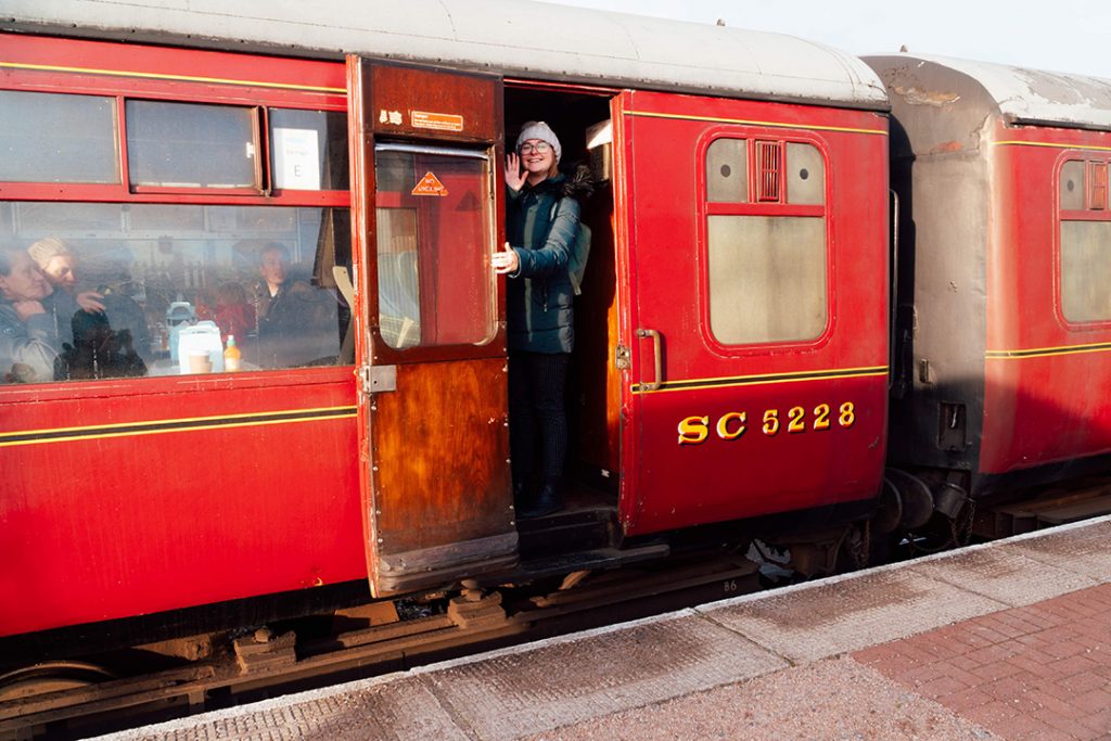 addie standing in the door of a red train car