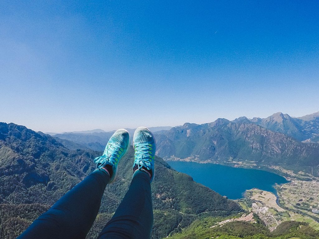 addie's feet in the air while paragliding over lake idro