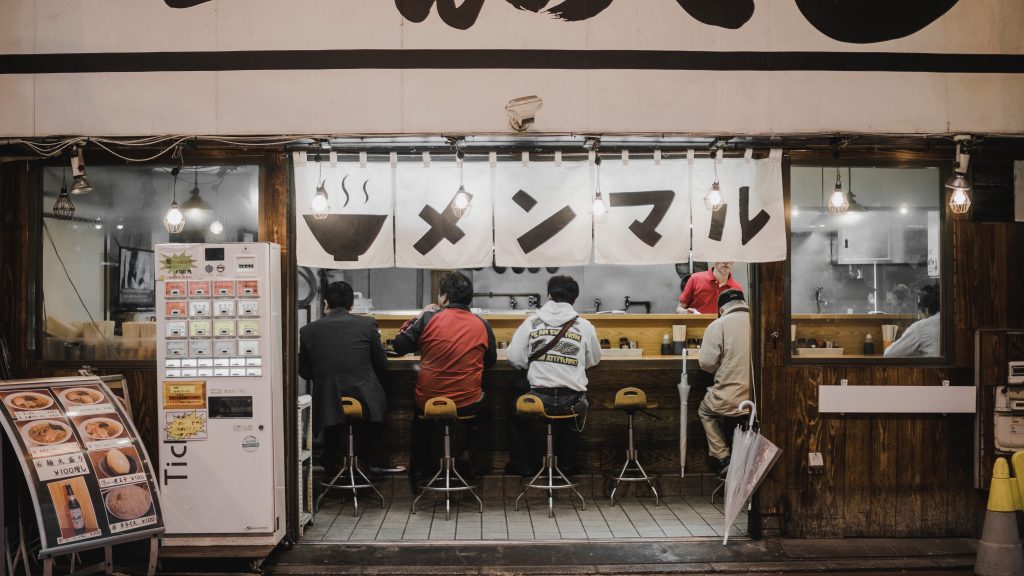 men sitting at a ramen bar - eating alone during solo female travel in japan isn't scary