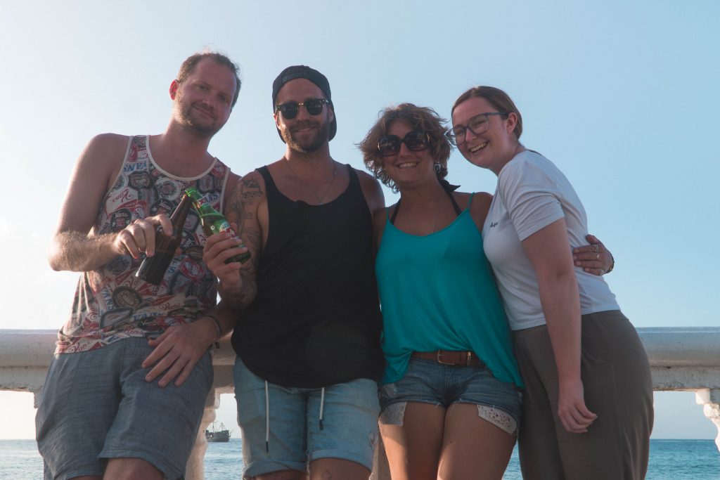 4 people smiling with their arms around each other
