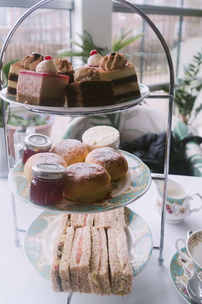 a three-tiered platter of sandwiches, scones, and desserts from afternoon tea at kensington palace - you can't miss this on your girls weekend in london