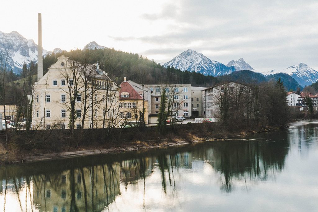 houses along a river in fussen with mountains in the background