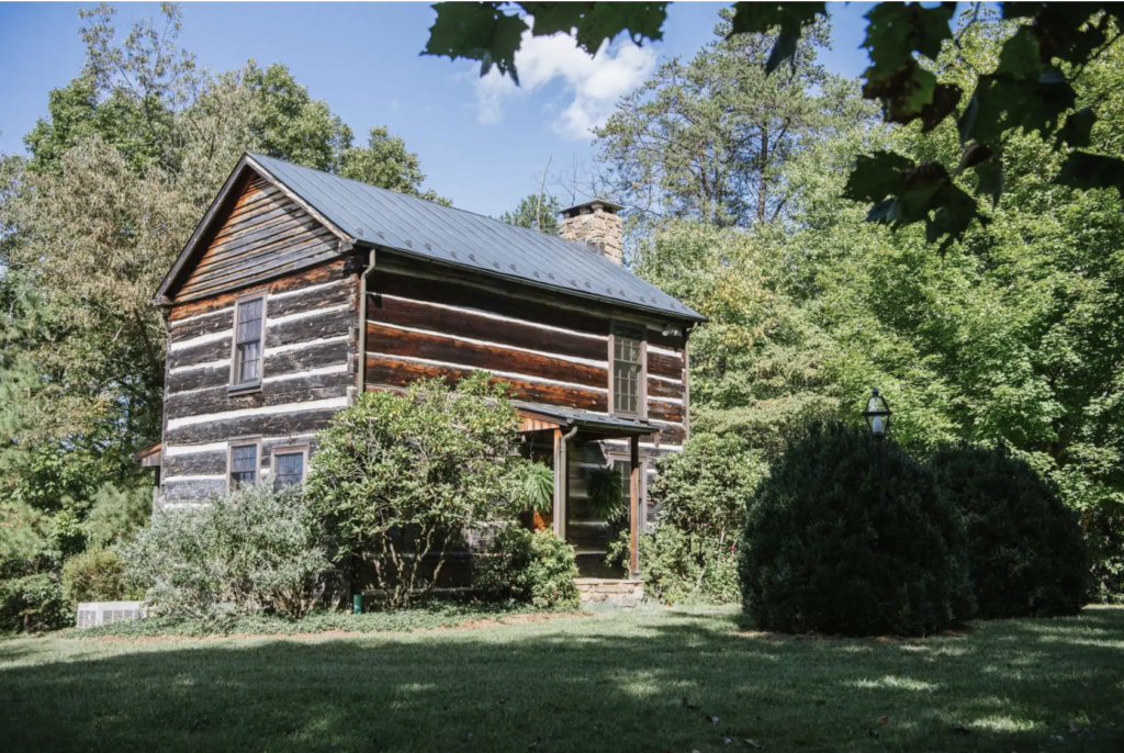 a 2-story log cabin in the woods