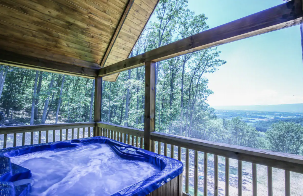 a hot tub on a deck with views over the valley below