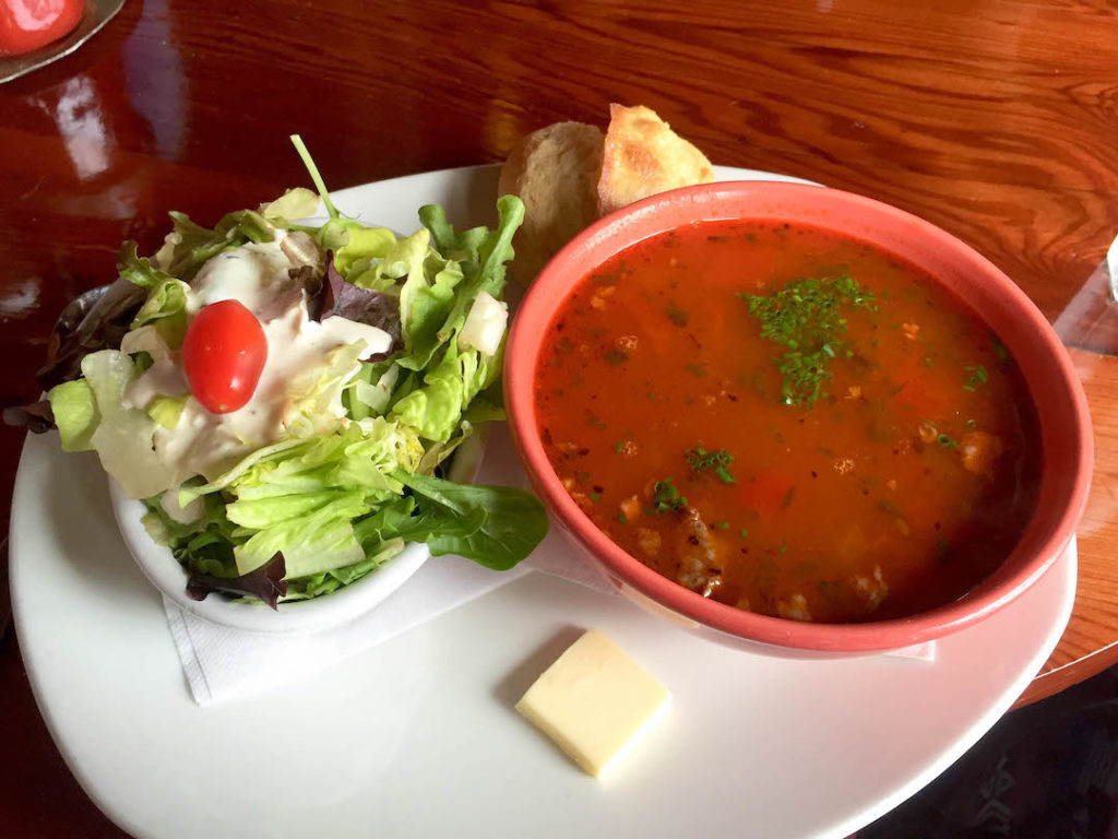 a bowl of tomato soup and salad from Nepenthe
