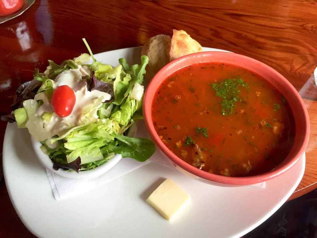 a bowl of tomato soup and salad from Nepenthe