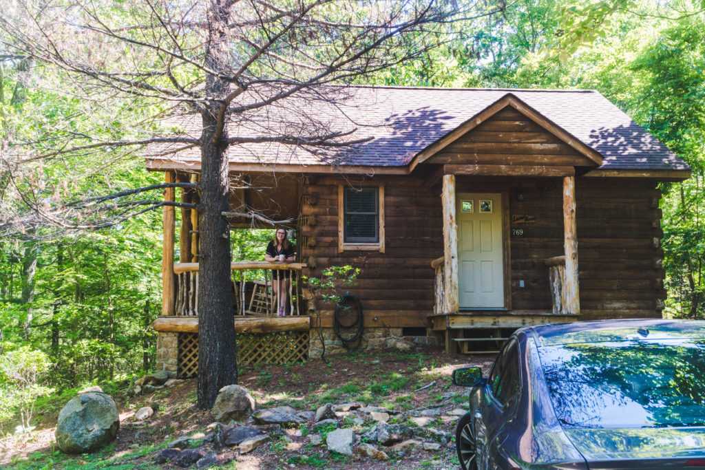 addie standing on the porch of a shenandoah national park cabin smiling